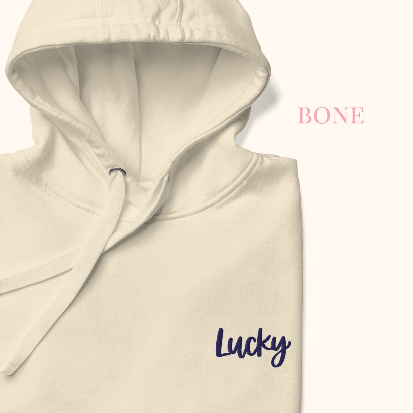 Beige hoodie with 'Lucky' text on a white background
