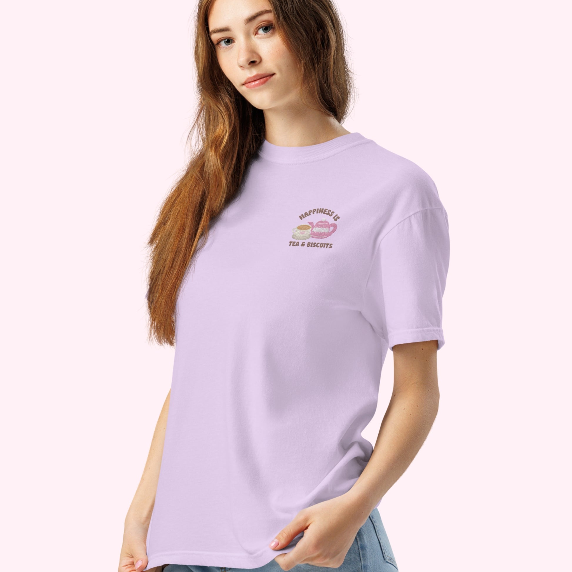 Close-up of "Happiness is Tea and Biscuits" script with a tiny embroidered teacup and teapot on a purple-coloured t-shirt.