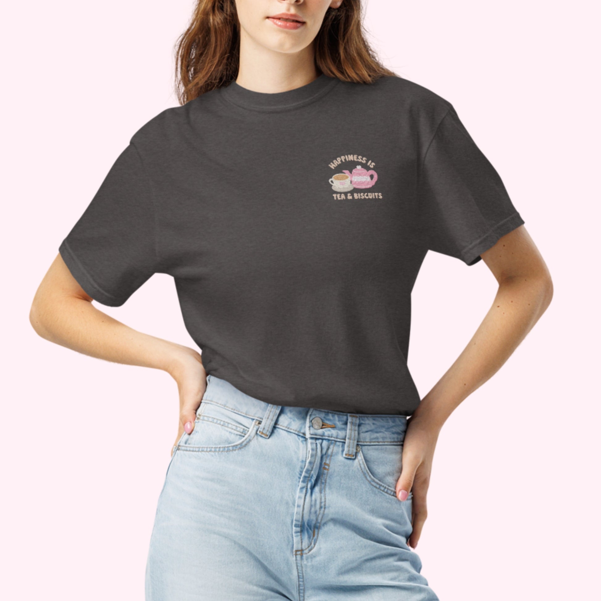 Close-up of "Happiness is Tea and Biscuits" script with a tiny embroidered teacup and teapot on a graphite grey-coloured t-shirt