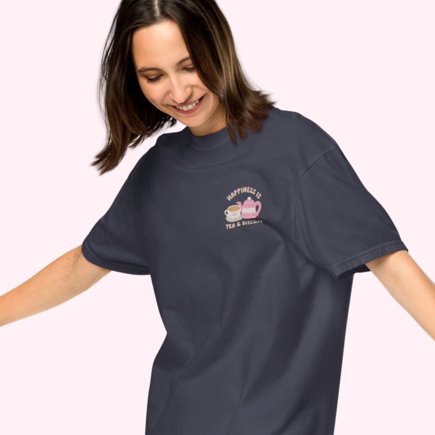 Close-up of "Happiness is Tea and Biscuits" script with a tiny embroidered teacup and teapot on a navy-coloured t-shirt.