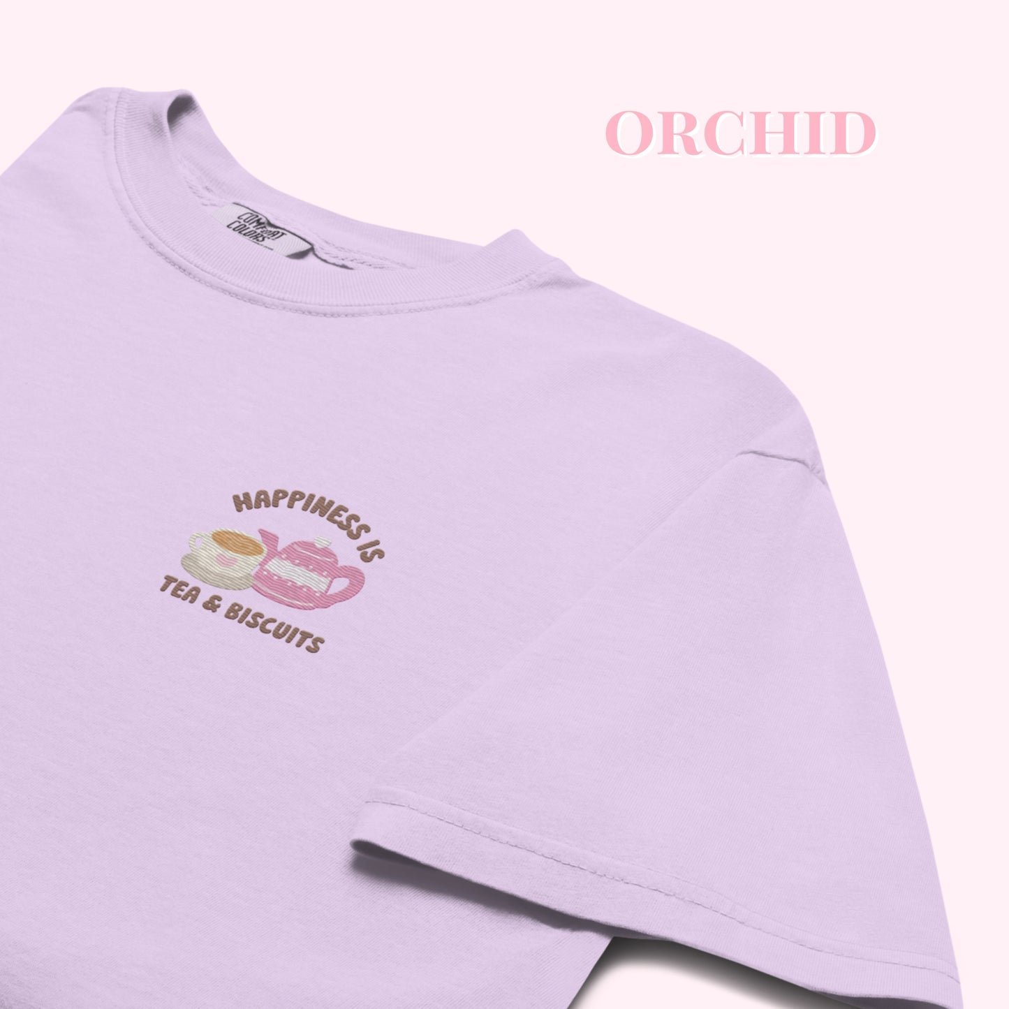 Light purple tshirt with 'Happiness is Tea & Biscuits' embroideredtext and graphics on a white background