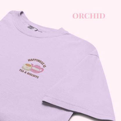 Light purple tshirt with 'Happiness is Tea & Biscuits' embroideredtext and graphics on a white background