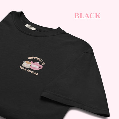 Black t-shirt with a embroidered happiness is tea and biscuits design and text on a white background