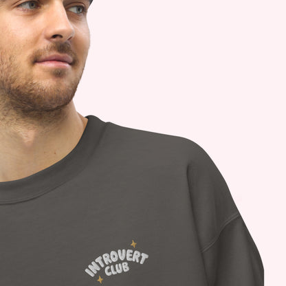 Man wearing a dark gray sweatshirt with 'Introvert Club' text on a white background