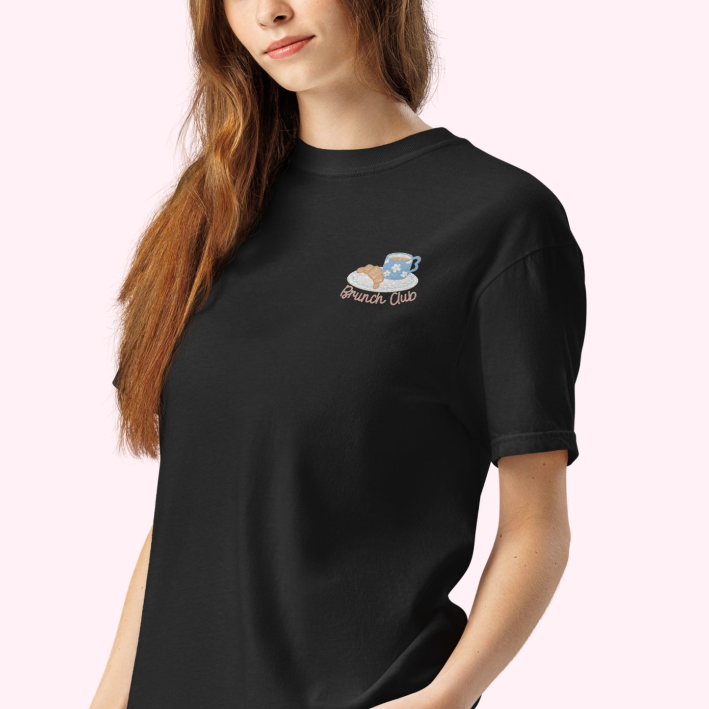 Women wearing a black t-shirt with 'Brunch Club' embroidered design, featuring a coffee cup and croissant illustration. Cafe slow life cozy girl