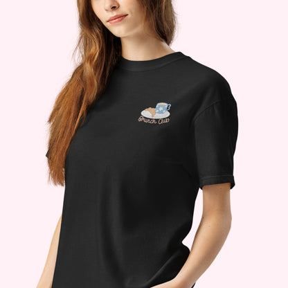 Women wearing a black t-shirt with 'Brunch Club' embroidered design, featuring a coffee cup and croissant illustration. Cafe slow life cozy girl