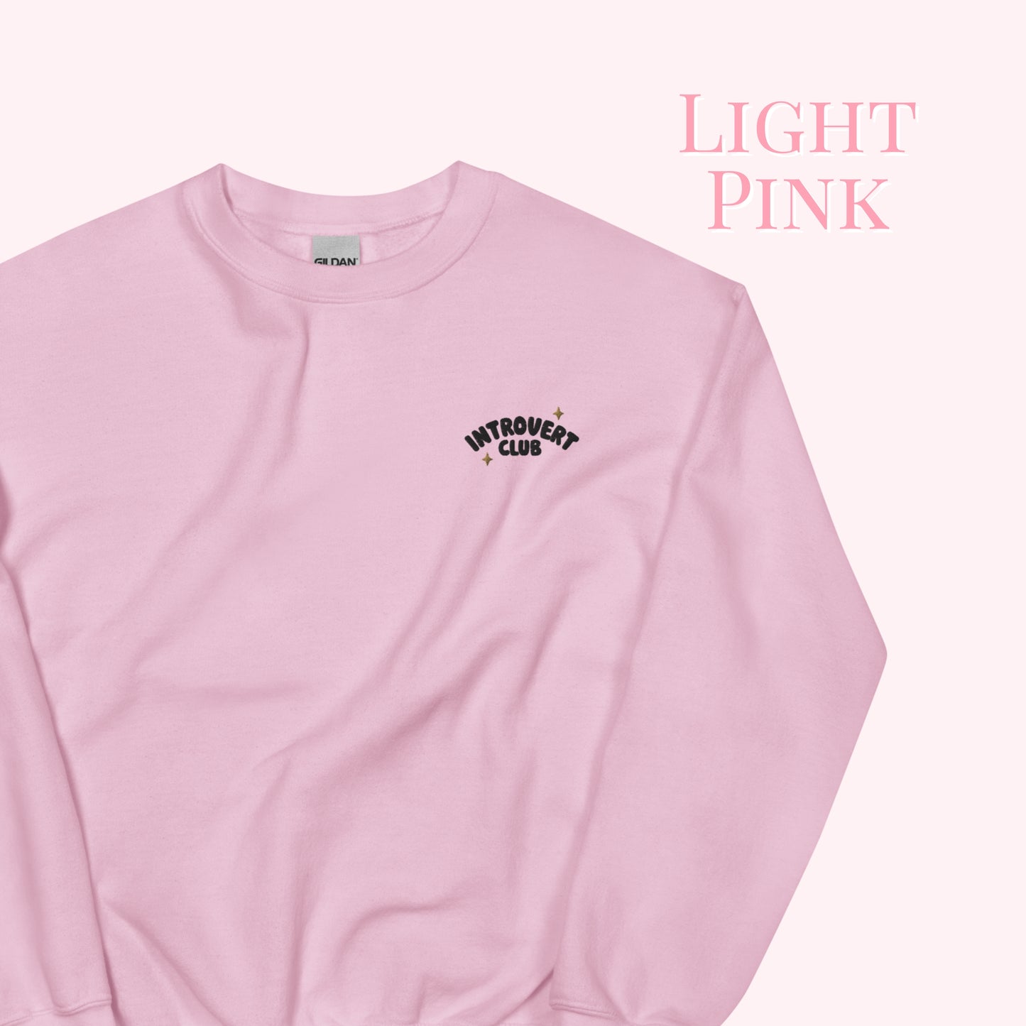 Light pink sweatshirt with 'Introvert Club' text on a white background