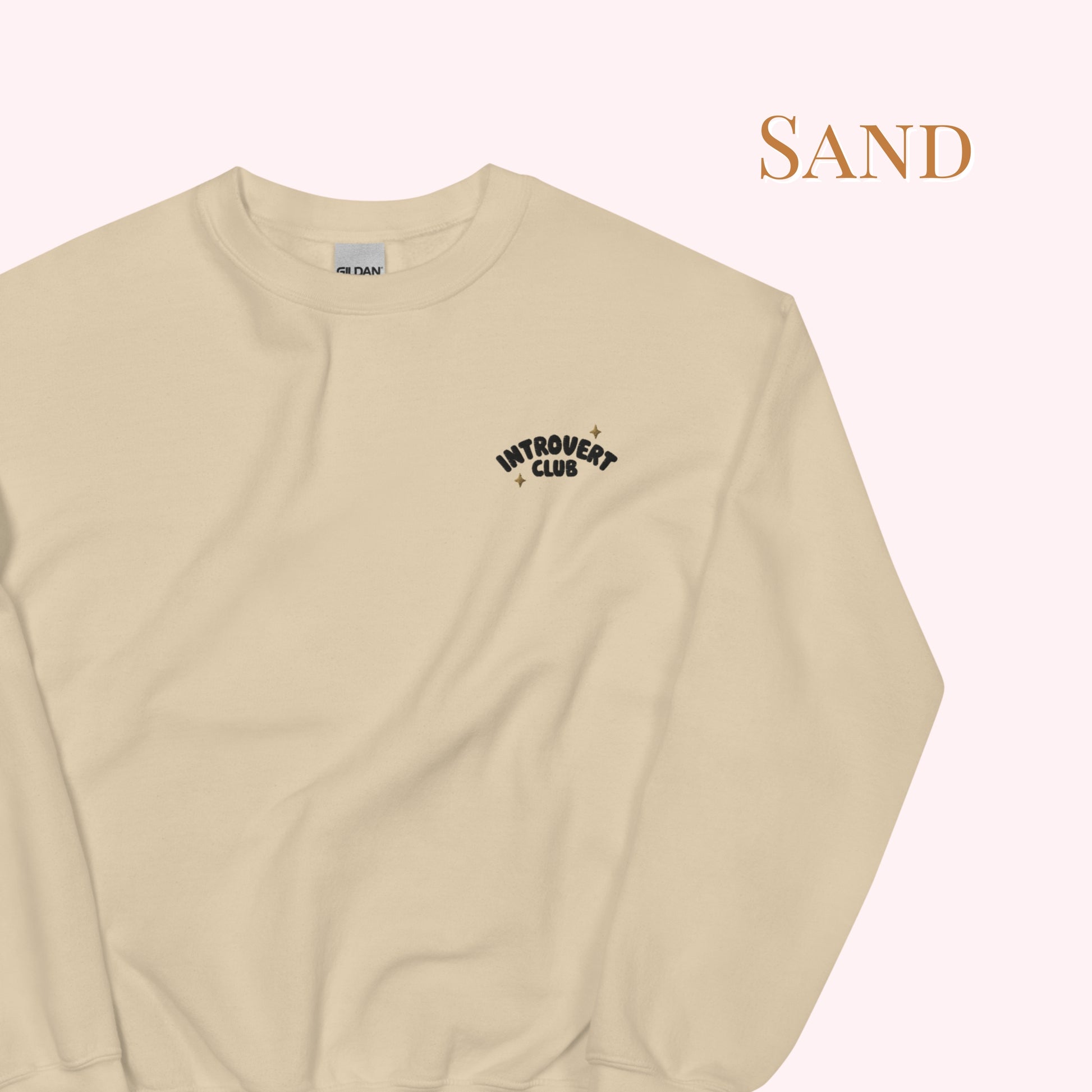 Sand coloured sweatshirt with 'Introvert Club' text on a light pink background
