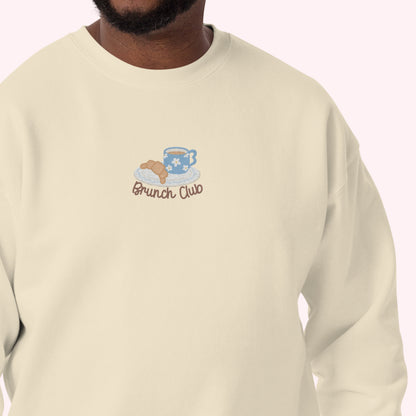 man wearing beige sweatshirt with 'Brunch Club' logo on a white background