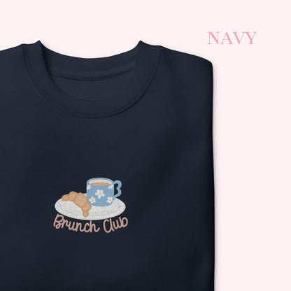 Navy sweatshirt with 'Brunch Club' design featuring a coffee cup and croissant on a white background.
