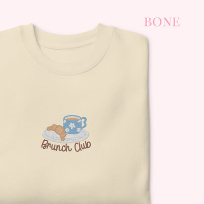 Beige sweatshirt with 'Brunch Club' embroidery featuring a coffee cup and pastry on a white background.