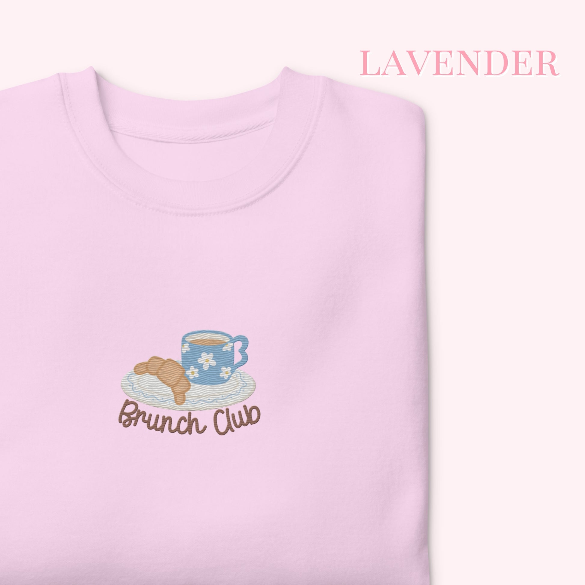 Lavender sweatshirt with 'Brunch Club' design featuring a teacup and croissant on a white background.