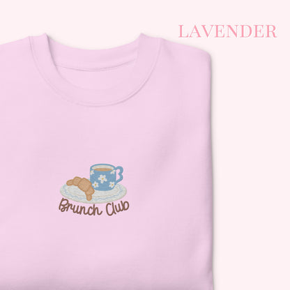 Lavender sweatshirt with 'Brunch Club' design featuring a teacup and croissant on a white background.