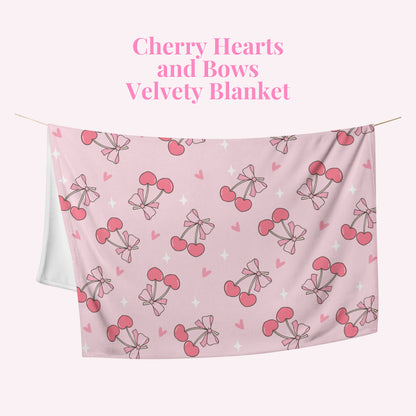 Pink velvety blanket with cherry hearts and bows pattern on a pink background