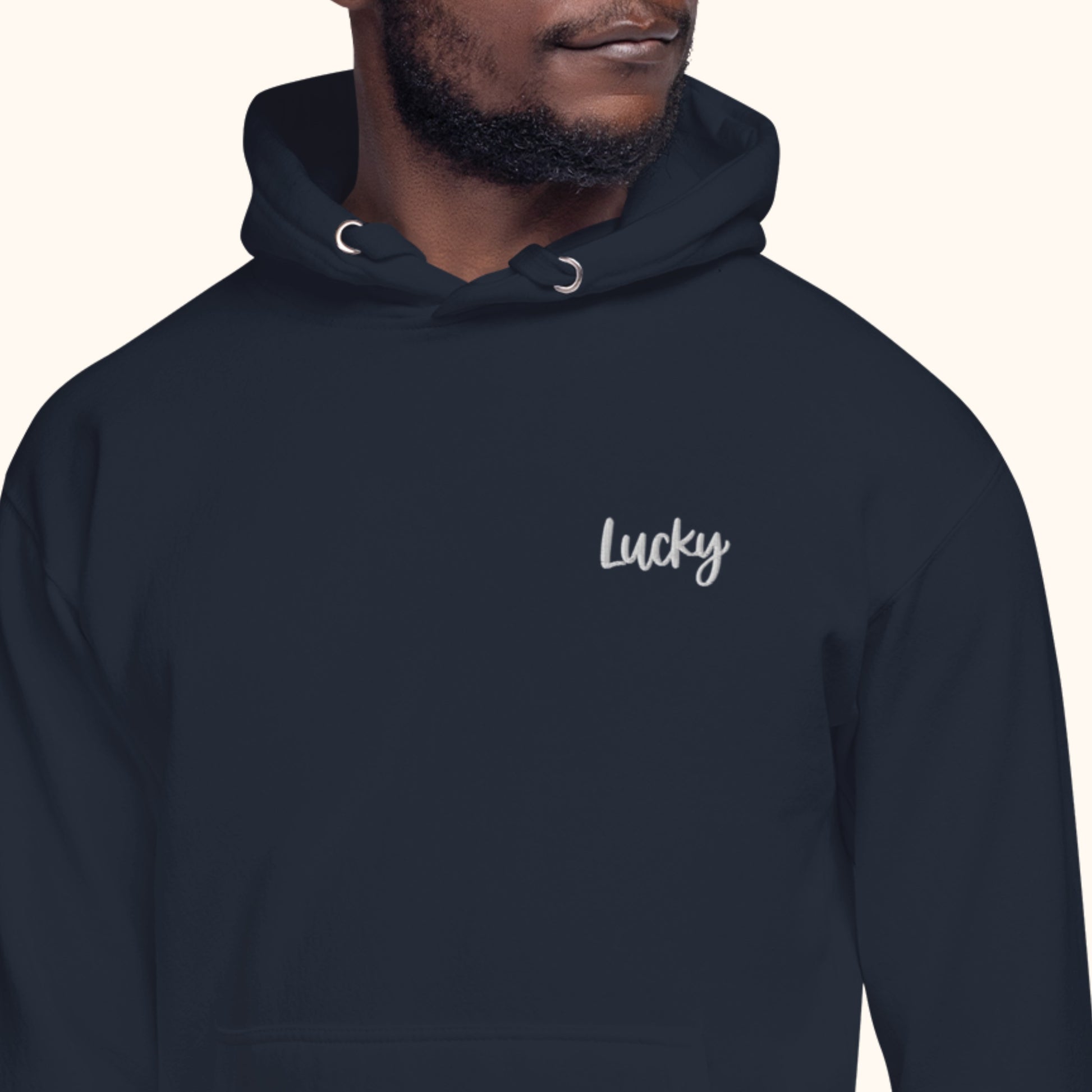 man wearing Navy hoodie with 'Lucky' text on a white background. lucky charm hoody