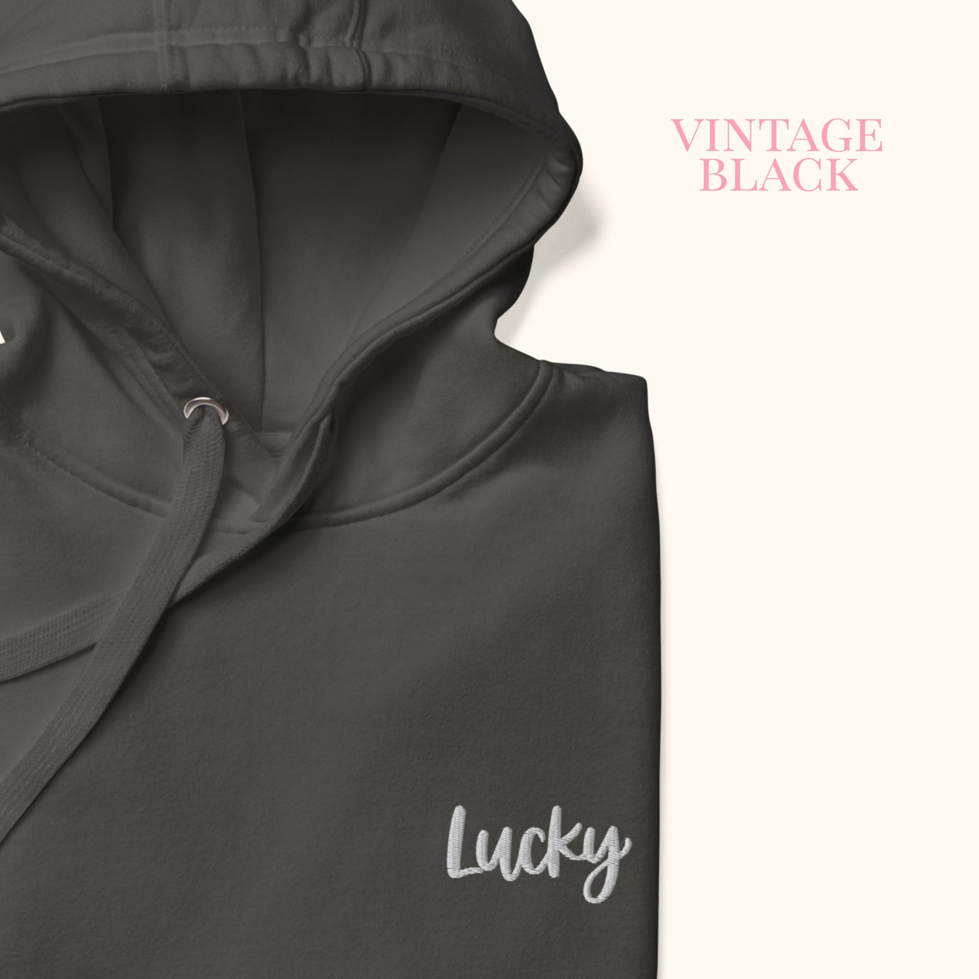 close up of Dark gray hoodie with 'Lucky' embroidery on a white background