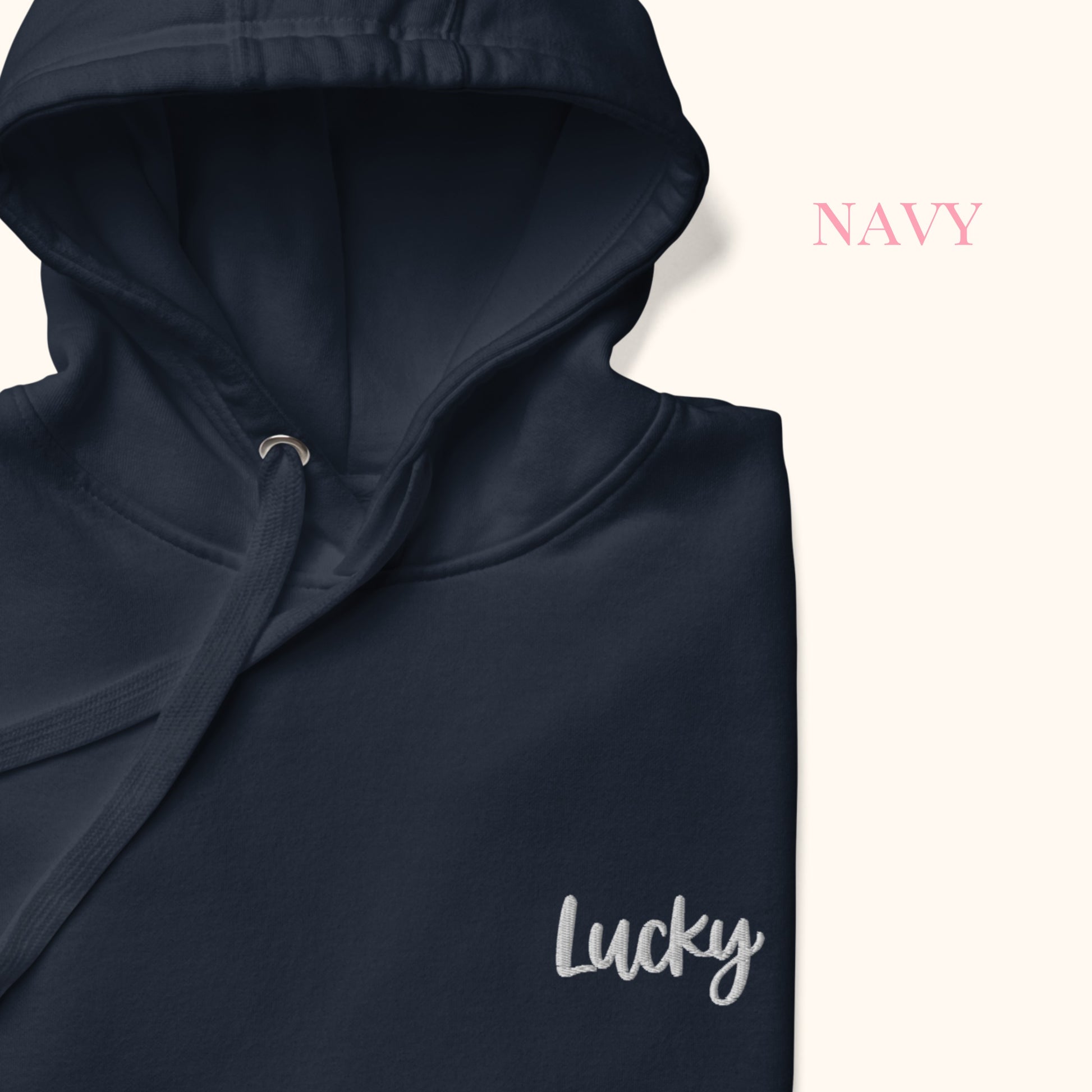 close up of Navy hoodie with 'Lucky' embroidery on a white background