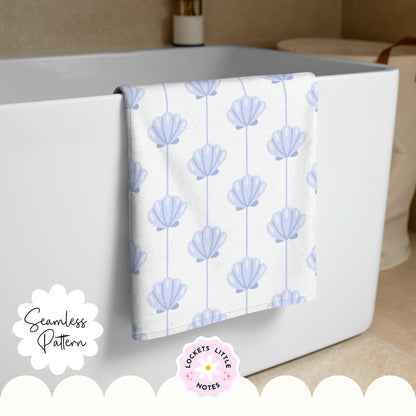 Seamless coastal pattern featuring a crisp white background with fine vertical blue pinstripes and a repeating scatter of detailed blue clam shells. Towel with shell pattern hanging over a bathtub