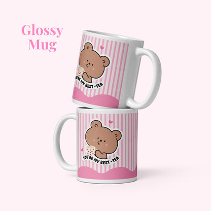 Two pink mugs with bear illustrations and text on a white background