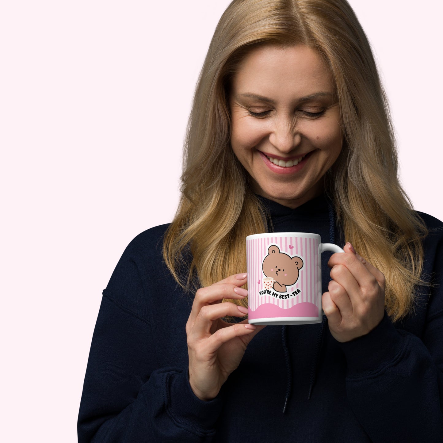 Woman holding a pink mug with a cartoon bear design on a white background