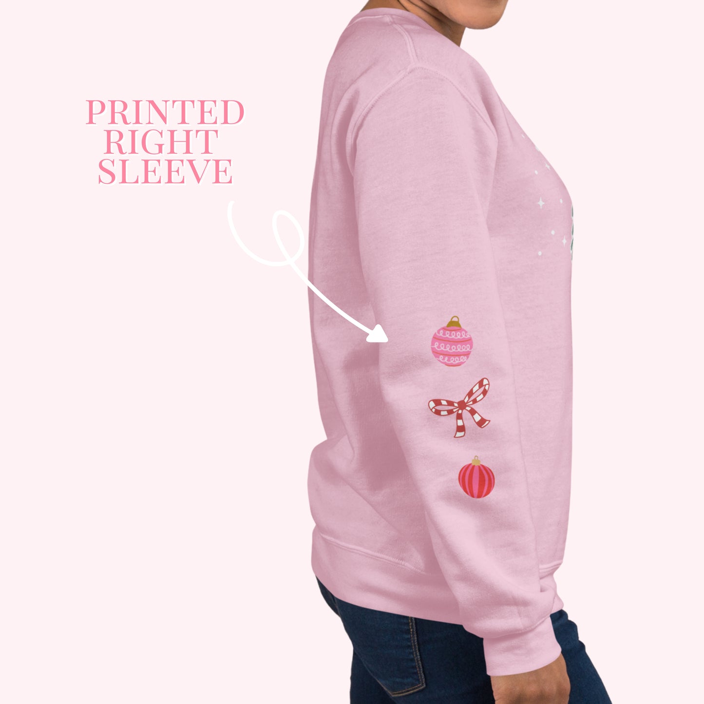 Pink sweatshirt with printed designs on the right sleeve, worn by a person.
