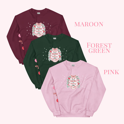 Three sweatshirts in maroon, forest green, and pink with a festive design on a white background.