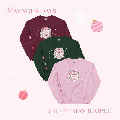 Three Christmas jumpers in maroon, green, and pink with festive designs on a white background.
